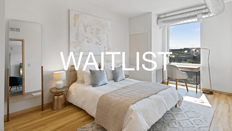 A bedroom with a large bed and a view of the city.